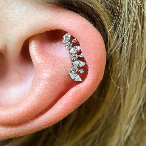 Close-up of an ear wearing a Titanium marquise and round gem crescent labret piercing.